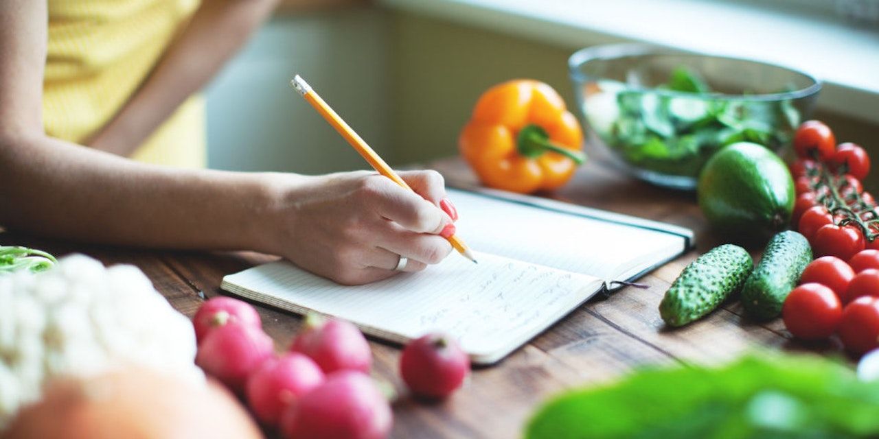 Nutrition Mastery: An Image of Diligent Individual Tracking Their Dietary Intake on a Notepad, Paving the Way to Health and Wellness Success.