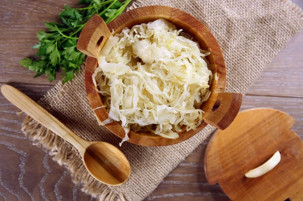 Image of a bowl filled with sauerkraut, a tangy and fermented dish made from shredded cabbage.